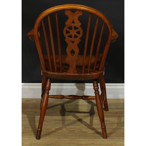 897 - A 19th century elm wheelback Windsor elbow chair, hoop back, shaped and pierced splat, saddle seat, ... 