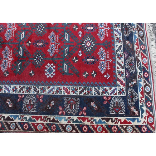 847 - A Middle Eastern rectangular wool rug or carpet, the field worked with hooked medallions and geometr... 