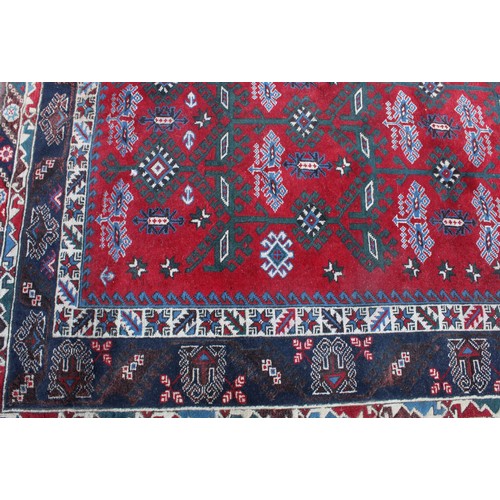 847 - A Middle Eastern rectangular wool rug or carpet, the field worked with hooked medallions and geometr... 