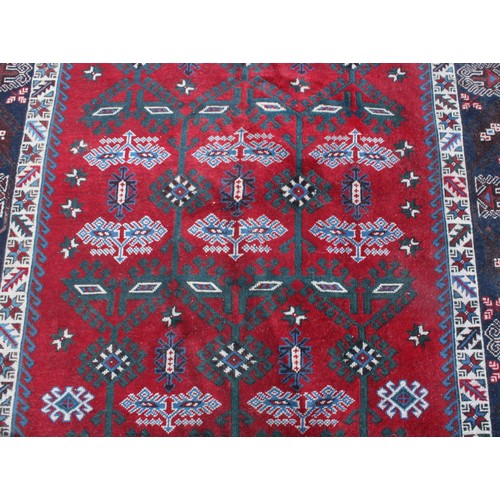 847 - A Middle Eastern rectangular wool rug or carpet, the field worked with hooked medallions and geometr... 