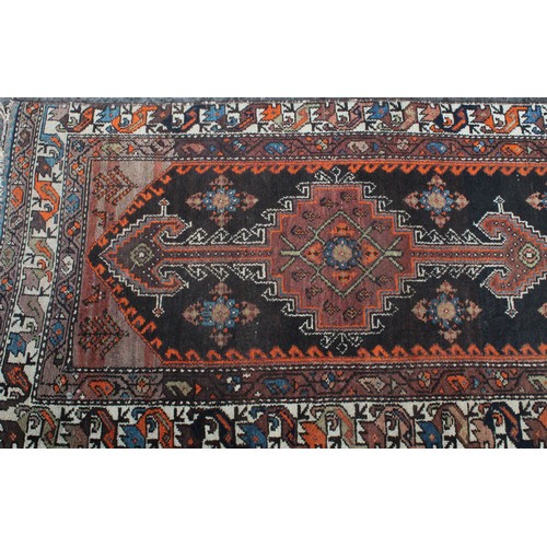 848 - A Middle Eastern wool runner rug, rectangular field worked with hooked medallions, banded borders wi... 