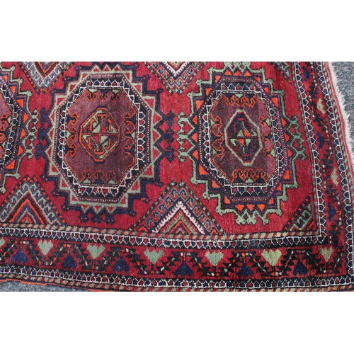 846 - A Middle Eastern rectangular wool rug or carpet, the field worked with hooked medallions and geometr... 