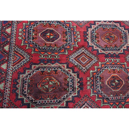 846 - A Middle Eastern rectangular wool rug or carpet, the field worked with hooked medallions and geometr... 