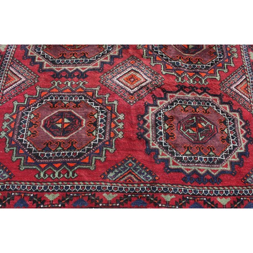 846 - A Middle Eastern rectangular wool rug or carpet, the field worked with hooked medallions and geometr... 