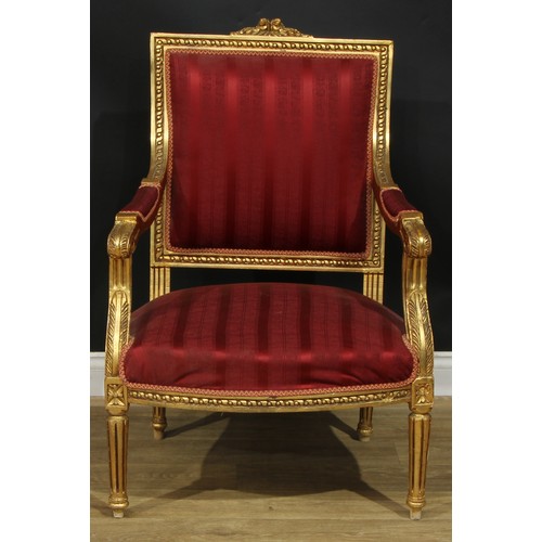 1402 - A pair of Louis XVI Revival giltwood fauteuils, each with stuffed-over upholstery, fluted tapered cy... 