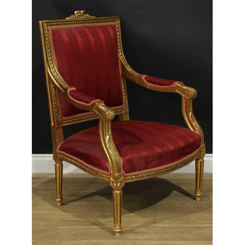 1402 - A pair of Louis XVI Revival giltwood fauteuils, each with stuffed-over upholstery, fluted tapered cy... 