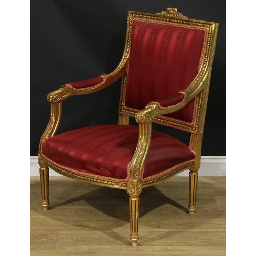 1402 - A pair of Louis XVI Revival giltwood fauteuils, each with stuffed-over upholstery, fluted tapered cy... 