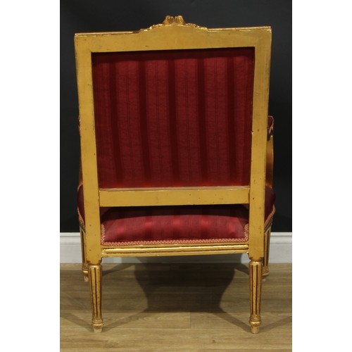 1402 - A pair of Louis XVI Revival giltwood fauteuils, each with stuffed-over upholstery, fluted tapered cy... 