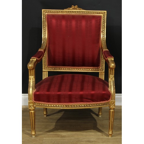 1402 - A pair of Louis XVI Revival giltwood fauteuils, each with stuffed-over upholstery, fluted tapered cy... 