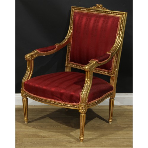 1402 - A pair of Louis XVI Revival giltwood fauteuils, each with stuffed-over upholstery, fluted tapered cy... 