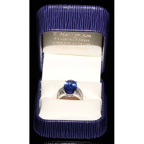 368 - An 18ct white gold diamond and tanzanite ring, 5.83ct central oval tanzanite, flanked by ten baguett... 