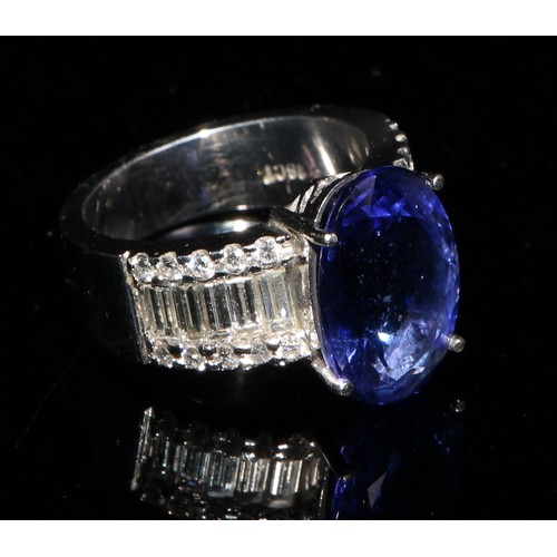 368 - An 18ct white gold diamond and tanzanite ring, 5.83ct central oval tanzanite, flanked by ten baguett... 