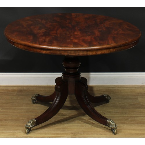 1424 - A Regency mahogany centre table, oval tilting top, turned column, sabre legs, brass capped casters, ... 