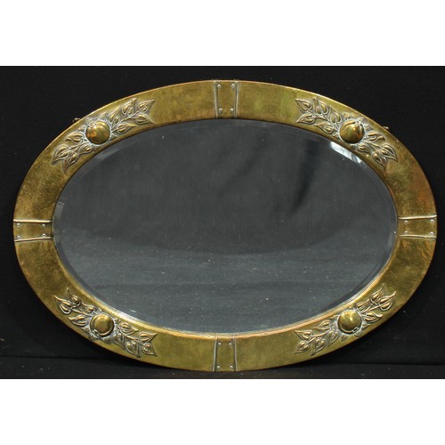 1362 - An Arts and Crafts oval looking glass, bevelled mirror plate, brass frame embossed with stiff leaves... 