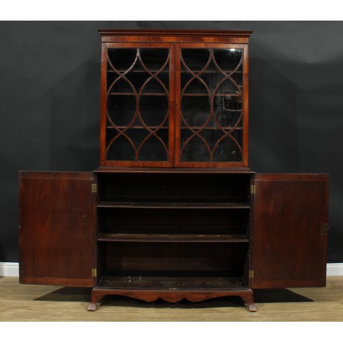 1220 - A George III mahogany library bookcase, outswept cornice above a pair of glazed doors enclosing thre... 