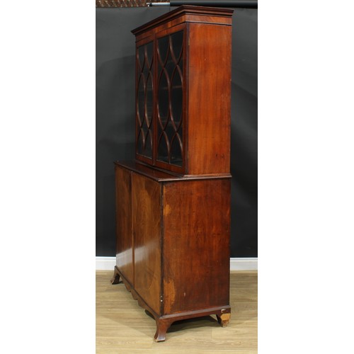 1220 - A George III mahogany library bookcase, outswept cornice above a pair of glazed doors enclosing thre... 