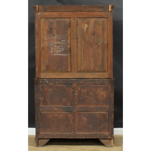 1220 - A George III mahogany library bookcase, outswept cornice above a pair of glazed doors enclosing thre... 