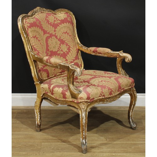 1351 - A Louis XV Revival giltwood fauteuil, in the manner of Blaise Maucuy, stuffed-over upholstery, cabri... 