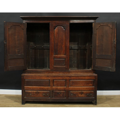 1162 - A George III oak housekeeper’s provision or livery press cupboard, outswept cornice above a pair of ... 