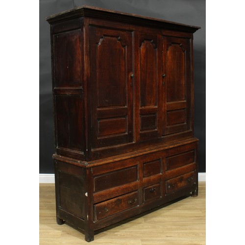 1162 - A George III oak housekeeper’s provision or livery press cupboard, outswept cornice above a pair of ... 