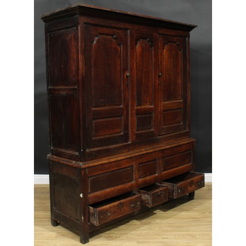 1162 - A George III oak housekeeper’s provision or livery press cupboard, outswept cornice above a pair of ... 