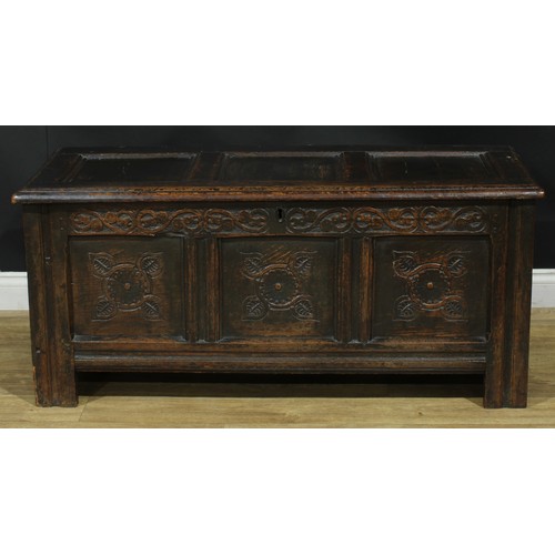 1295 - A late 17th/early 18th century oak blanket chest, hinged top above a three panel front carved with s... 