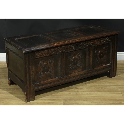 1295 - A late 17th/early 18th century oak blanket chest, hinged top above a three panel front carved with s... 