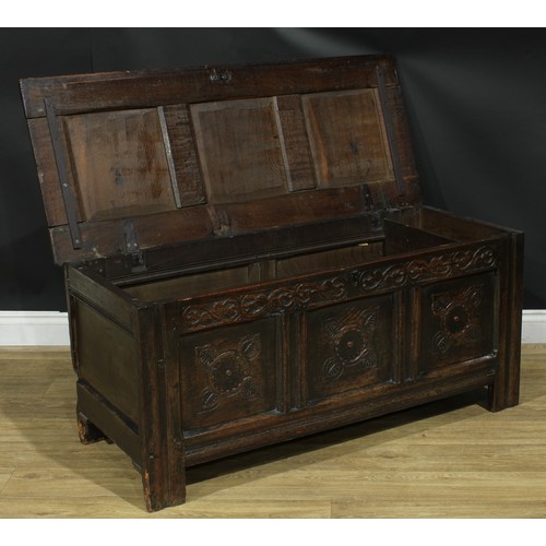 1295 - A late 17th/early 18th century oak blanket chest, hinged top above a three panel front carved with s... 