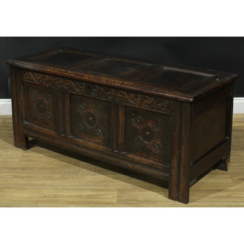 1295 - A late 17th/early 18th century oak blanket chest, hinged top above a three panel front carved with s... 