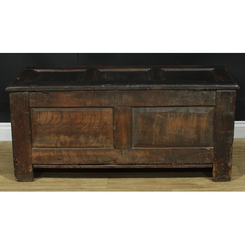 1295 - A late 17th/early 18th century oak blanket chest, hinged top above a three panel front carved with s... 