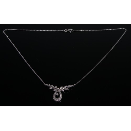 373 - An diamond and 18ct white gold ribbon tied pendant necklace, the central poop with diamond solitaire... 