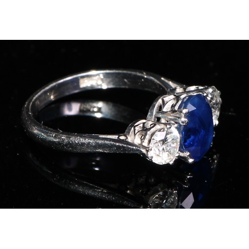 358 - A three stone diamond, sapphire and 18ct gold ring, the central oval sapphire flanked by a pair of b... 