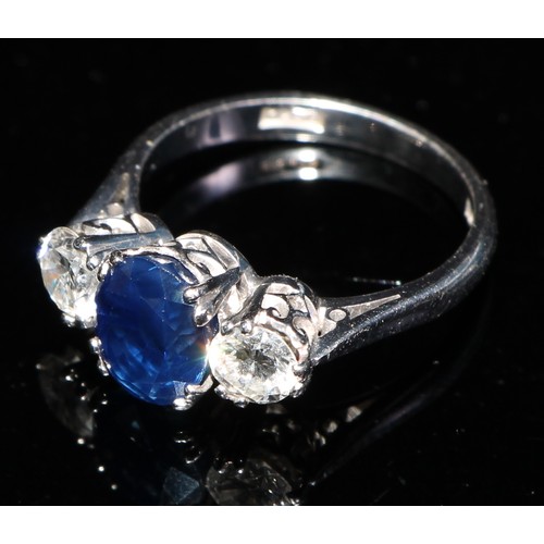 358 - A three stone diamond, sapphire and 18ct gold ring, the central oval sapphire flanked by a pair of b... 