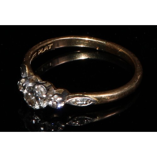 364 - An 18ct gold and platinum three stone diamond ring, diamond chips to navette shaped shoulders, size ... 