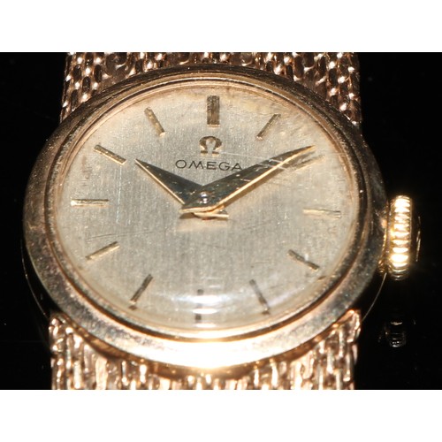 328 - A 9ct gold lady's Omega wristwatch, champagne dial, baton markers, side wind, fine mesh strap, 27g g... 