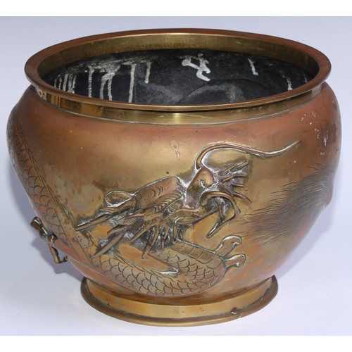 1077 - A Chinese bronze ovoid jardiniere, in relief with a ferocious dragon, 28cm diam, early 20th century