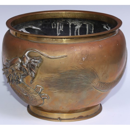 1077 - A Chinese bronze ovoid jardiniere, in relief with a ferocious dragon, 28cm diam, early 20th century