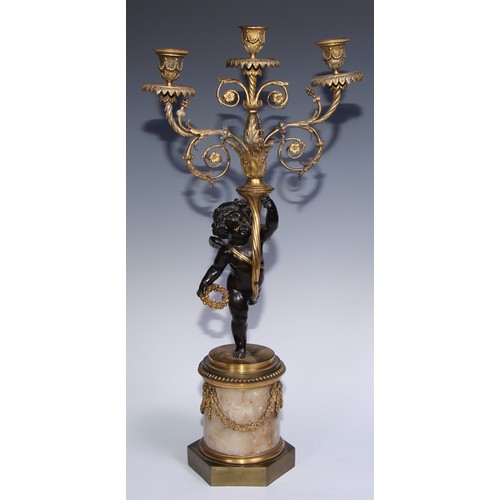 1384 - A pair of 19th century gilt and dark patinated bronze figural three-light candelabra, each cast as a... 