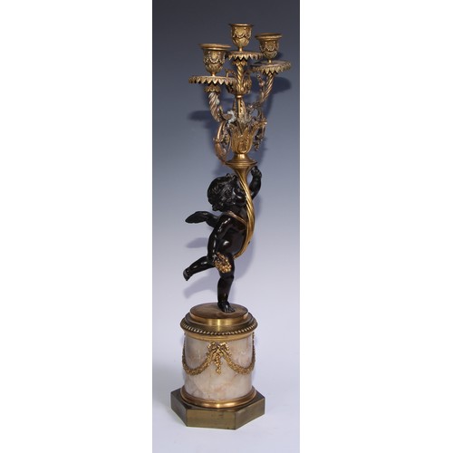 1384 - A pair of 19th century gilt and dark patinated bronze figural three-light candelabra, each cast as a... 