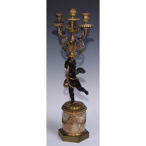 1384 - A pair of 19th century gilt and dark patinated bronze figural three-light candelabra, each cast as a... 