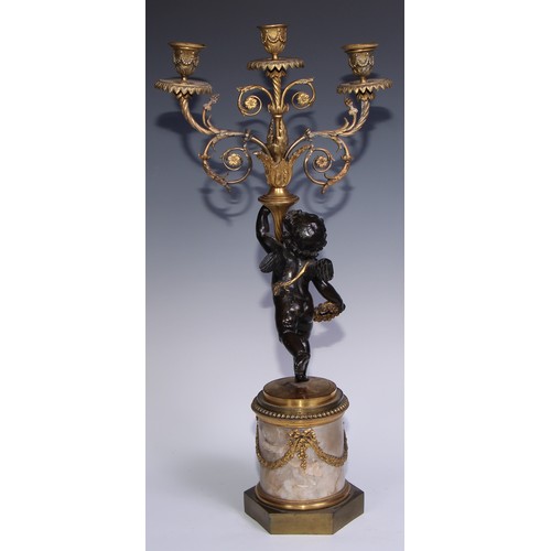 1384 - A pair of 19th century gilt and dark patinated bronze figural three-light candelabra, each cast as a... 