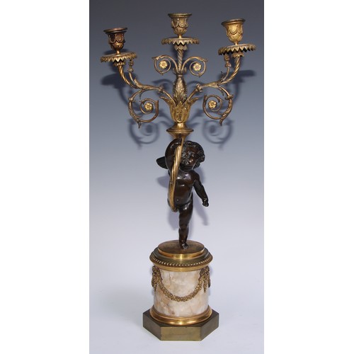 1384 - A pair of 19th century gilt and dark patinated bronze figural three-light candelabra, each cast as a... 