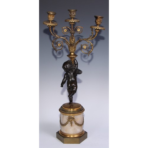 1384 - A pair of 19th century gilt and dark patinated bronze figural three-light candelabra, each cast as a... 