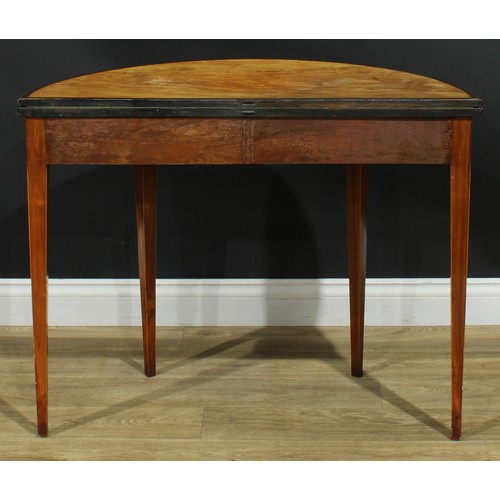 1182 - A George III tulipwood crossbanded satinwood demilune card table, hinged top enclosing a tooled baiz... 