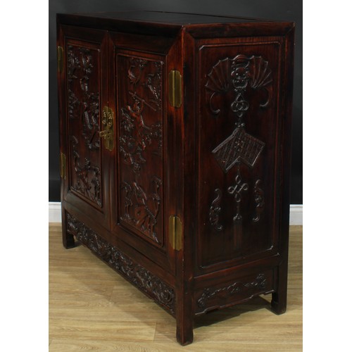 1043 - A Chinese hardwood side cabinet, flush rectangular top above a pair of panel doors carved with duell... 