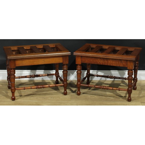 1400 - A pair of late Victorian walnut and mahogany rectangular luggage stands, each with oversailing slatt... 