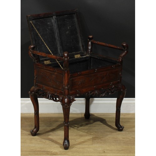 1049 - A Chinese padouk wood piano stool, hinged panel seat, carry handles to sides, carved and incised wit... 