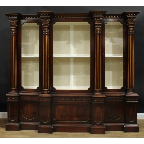 1001 - A 19th century style mahogany breakfront library bookcase, outswept cornice above three doors, each ... 