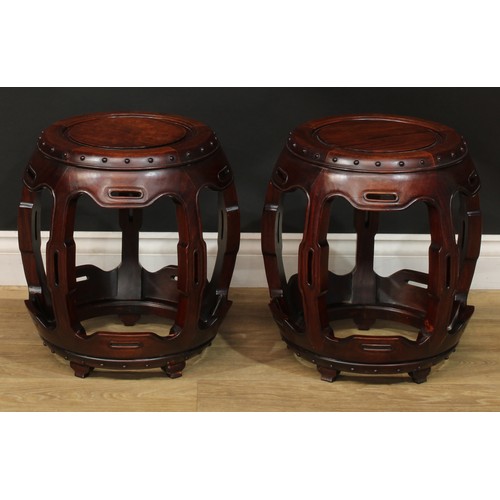 1378 - A pair of Chinese hardwood barrel-form seats or low tables, each with a circular top, shaped and pie... 