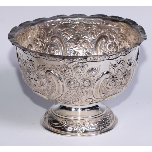 279 - An Edwardian silver pedestal bowl, chased with flowers, foliage and C-scrolls, wavy rim, domed base,... 